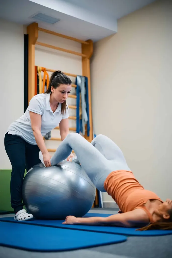 Exercice de réadaptation sur ballon avec une professionnelle de Physio St-Maurice